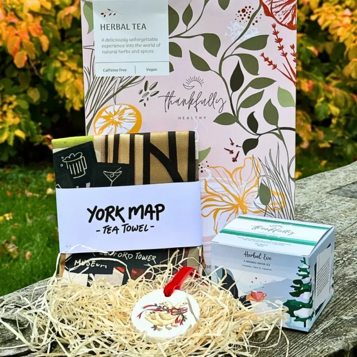 Celebrate the season of giving with our thoughtfully curated Tea Towel, Tea, and Handcrafted Christmas Disc Gift Box. This delightful hamper features one of our winter bestseller herbal tea, complementing it is a beautiful, hand-illustrated York City tea towel, printed on organic cotton—a unique and eco-conscious addition to any kitchen. To complete the festive charm, the set includes a handcrafted Christmas novelty disc featuring a traditional Christmas design, tied with a luxurious velvet ribbon.